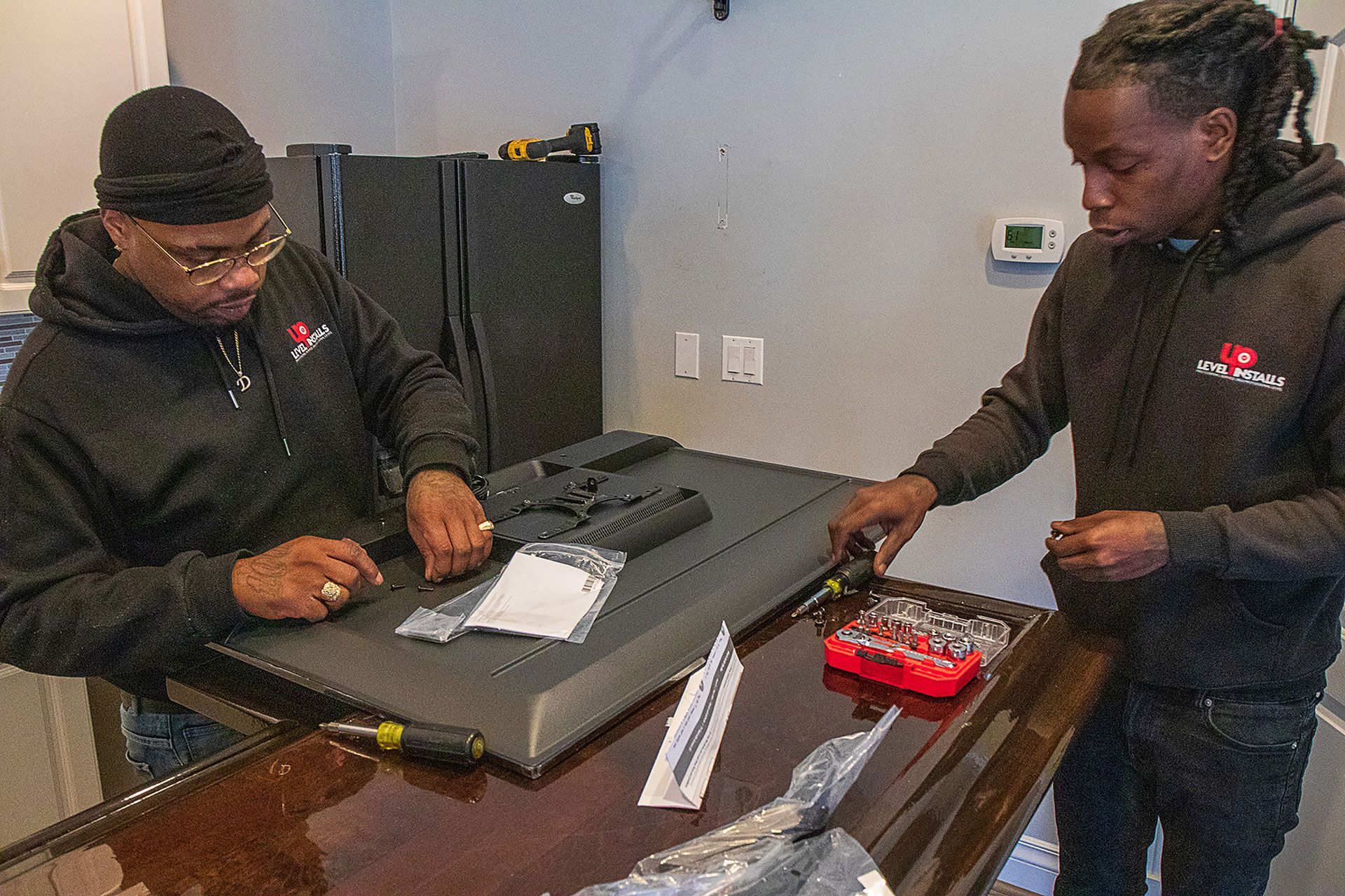 men preparing to mount the TV on the wall