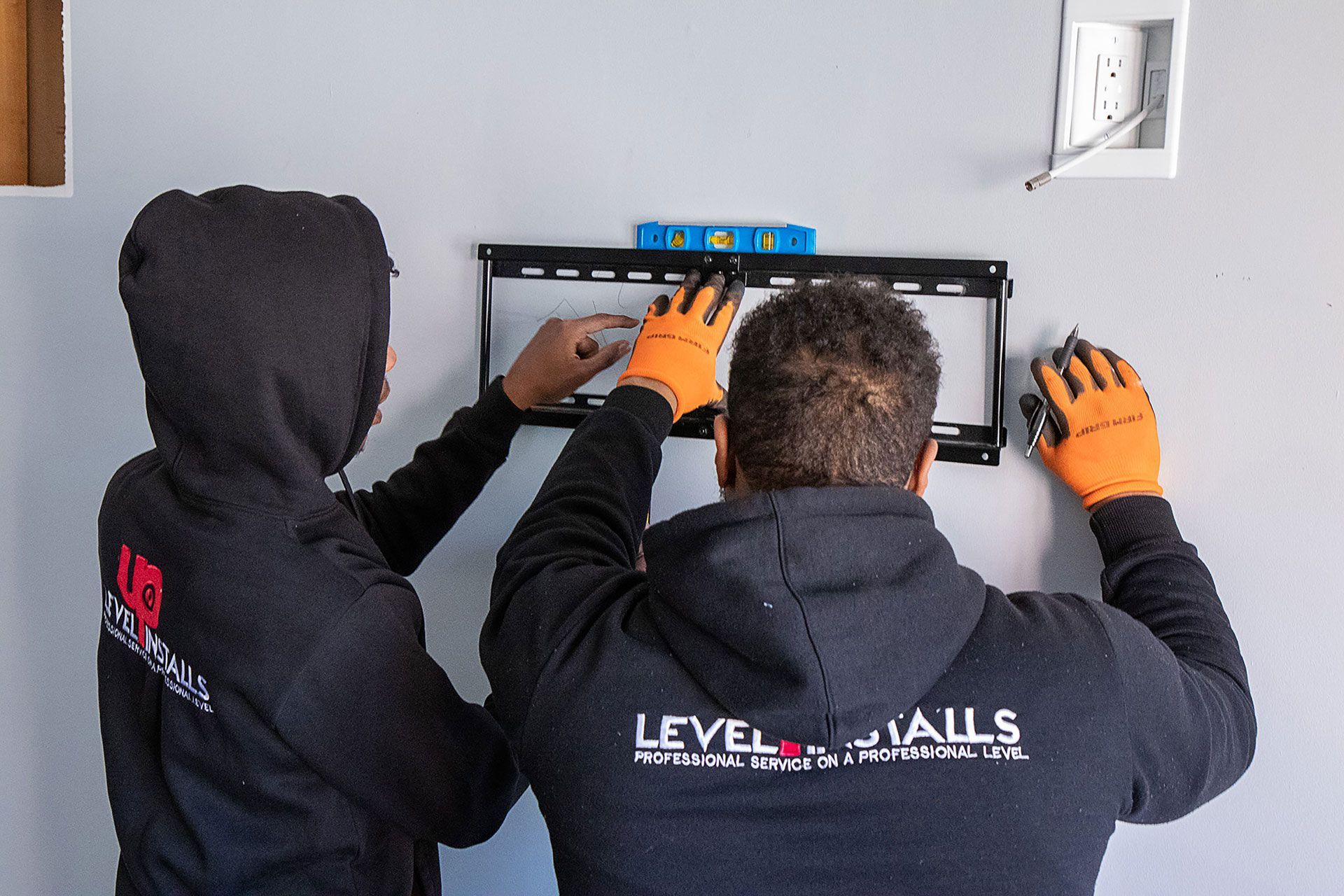 men adding markings to level the TV