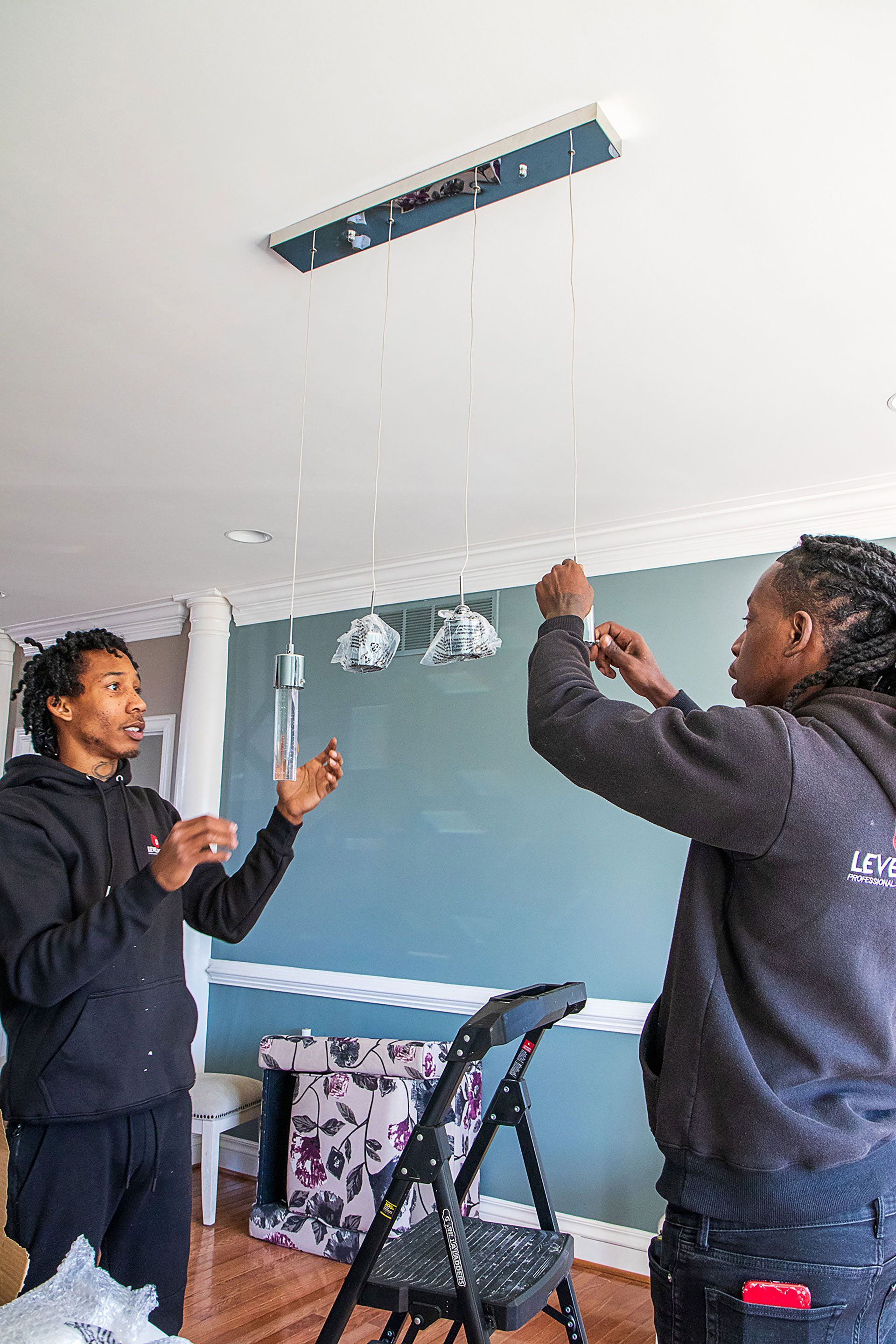 men removing the plastic from the lighting fixture