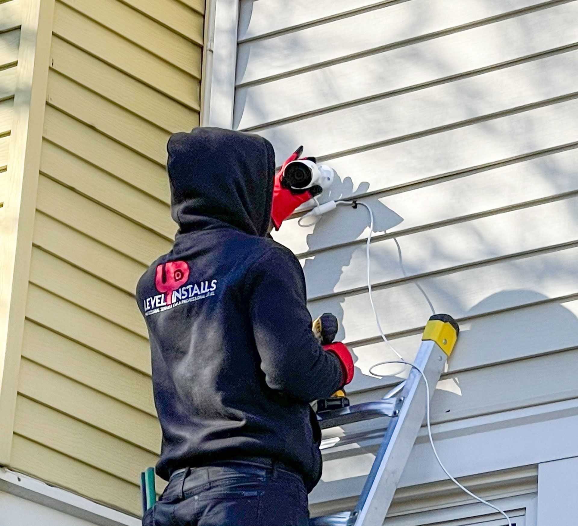 man on ladder mounting the CCTV