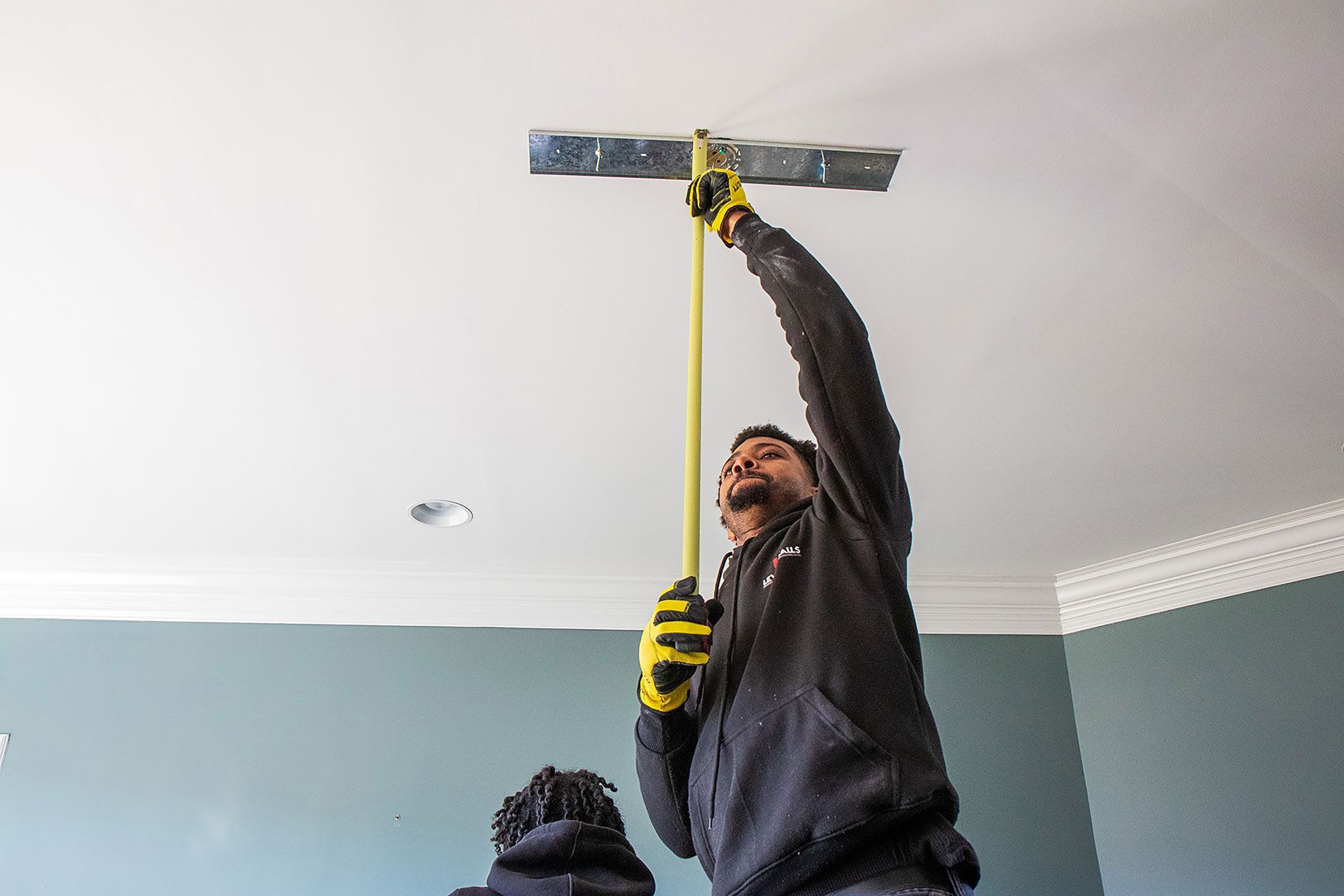 man measuring the hanging lights