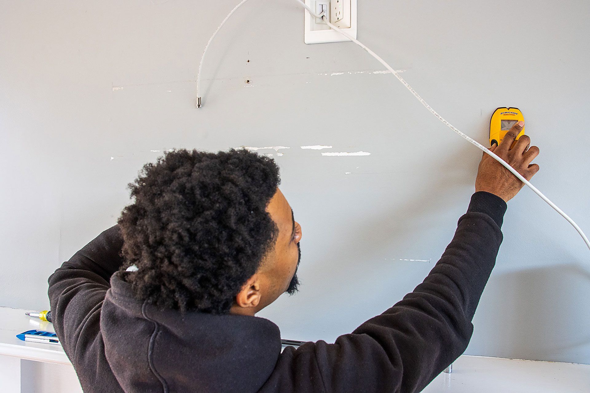 man measuring the wall for the TV