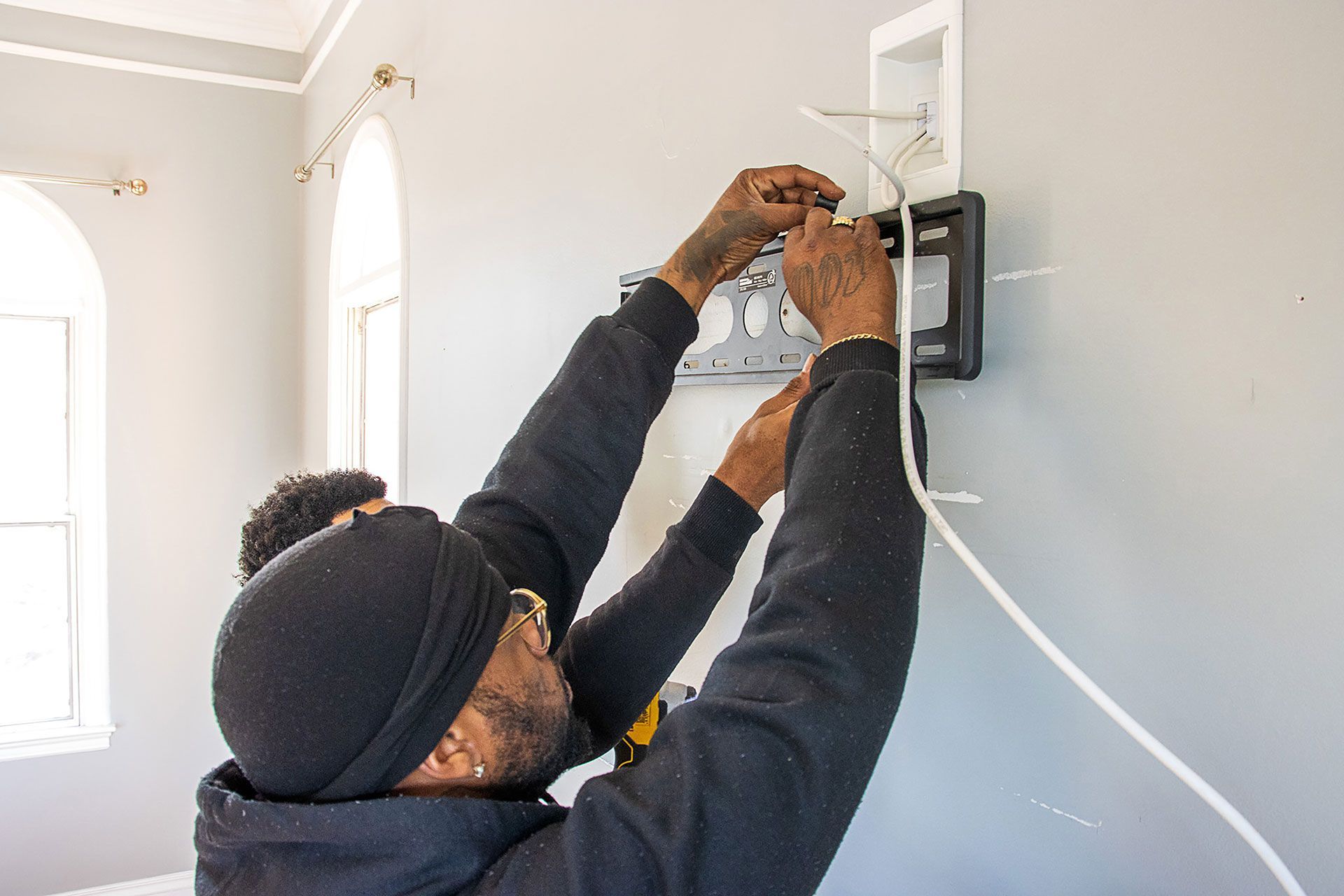 two men installing the TV brackets