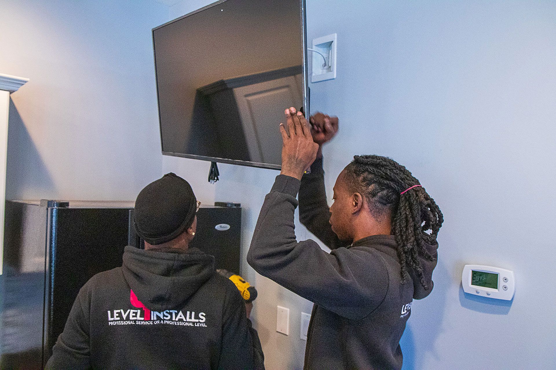 two men installing the flat screen TV