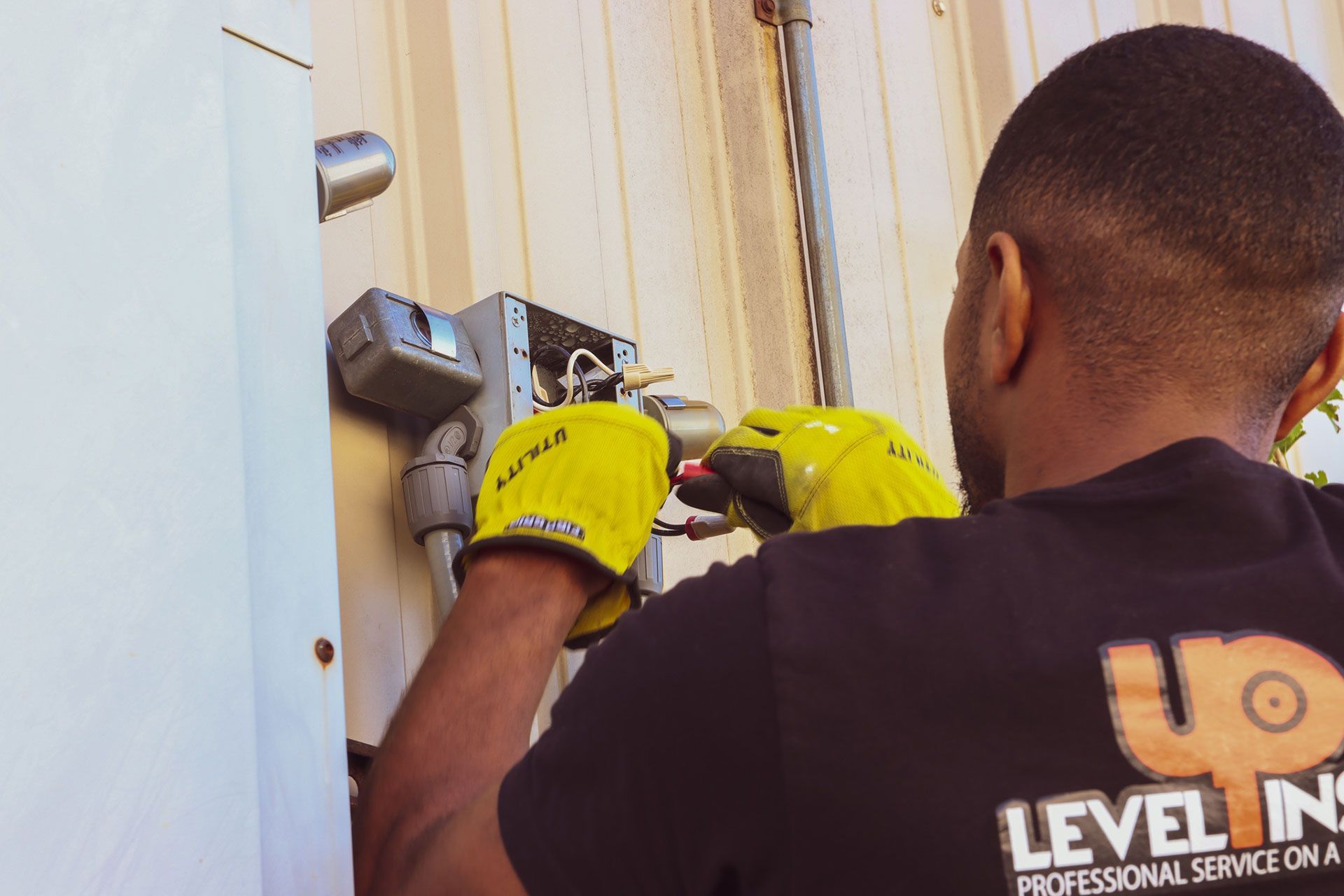 man with yellow gloves fixing the wiring