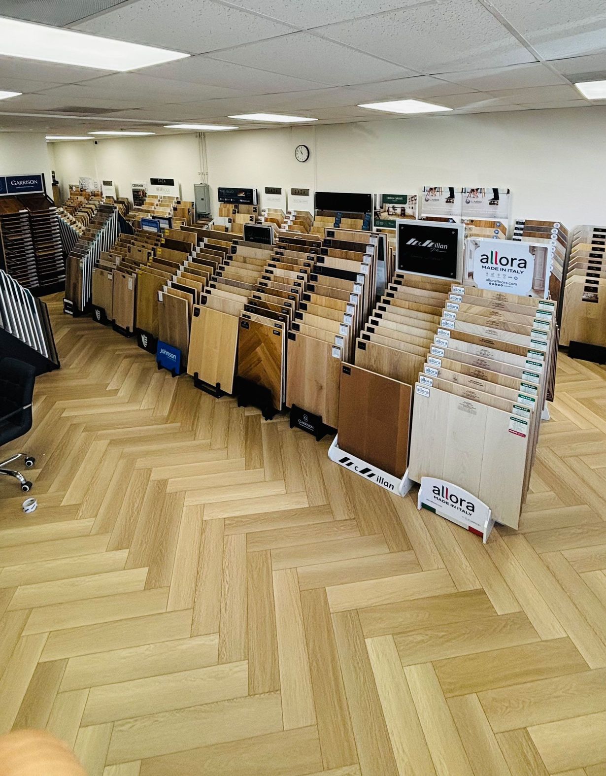 Rows of brown file folders on racks in a bright office with a herringbone wood floor.