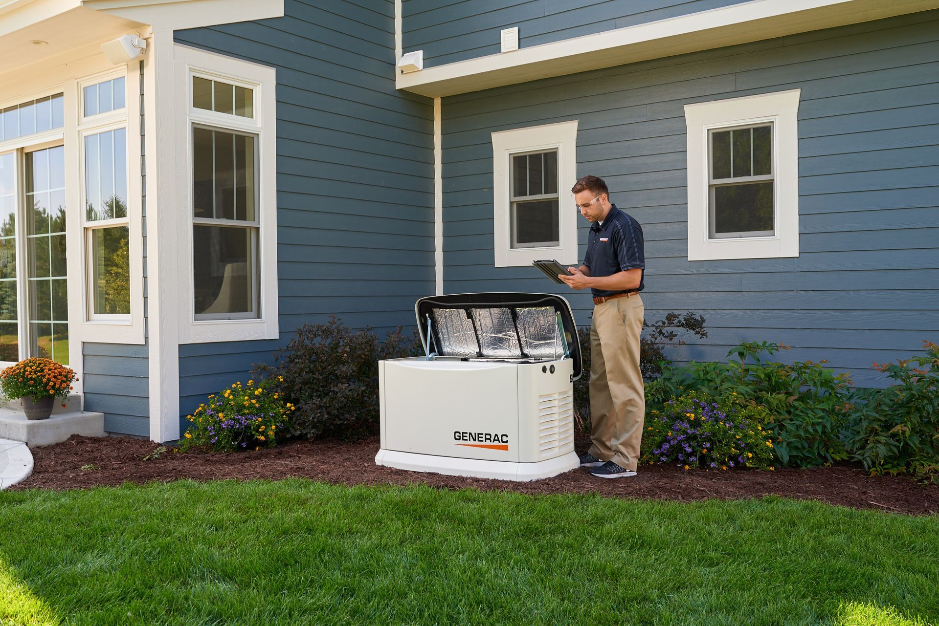 A white generator is sitting on top of a lush green lawn.
