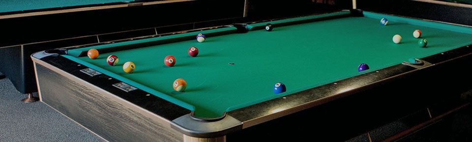 Pool table with balls scattered on top