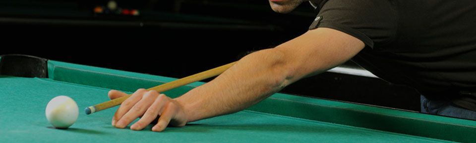 Man using a pool cue to hit a pool ball