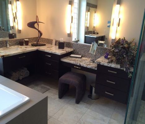 Bathroom vanity with dark cabinets, granite countertops, and modern lighting.