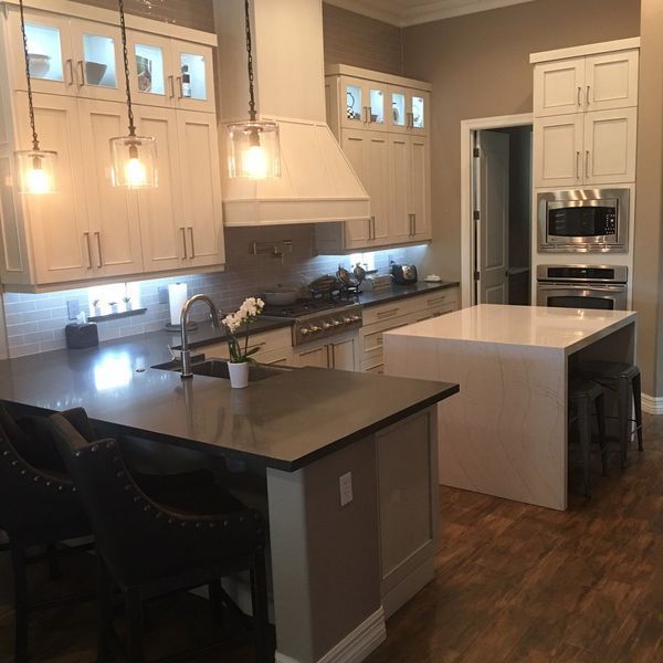 Modern kitchen with white cabinets, dark countertops, and an island.