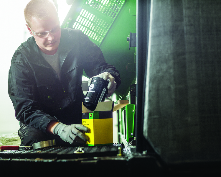 Man scanning a box with a barcode scanner near a large machine.