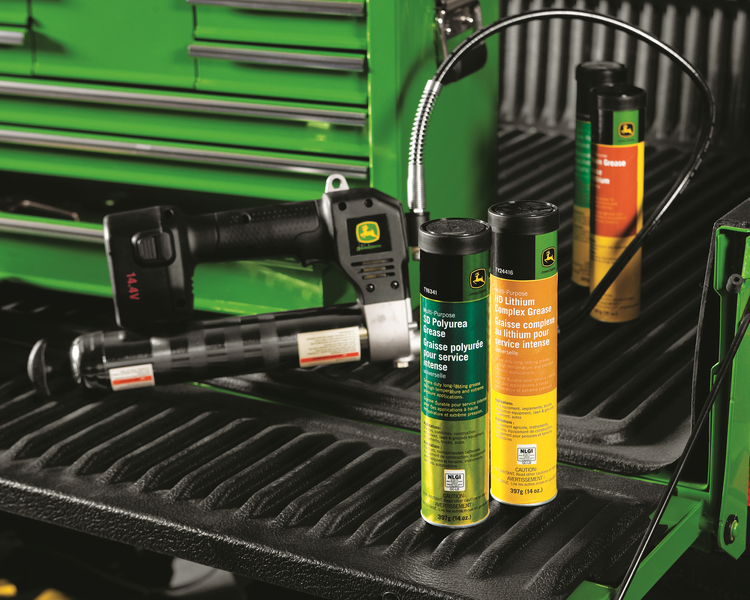 John Deere lubricants and grease gun in a truck bed, green and black colors.