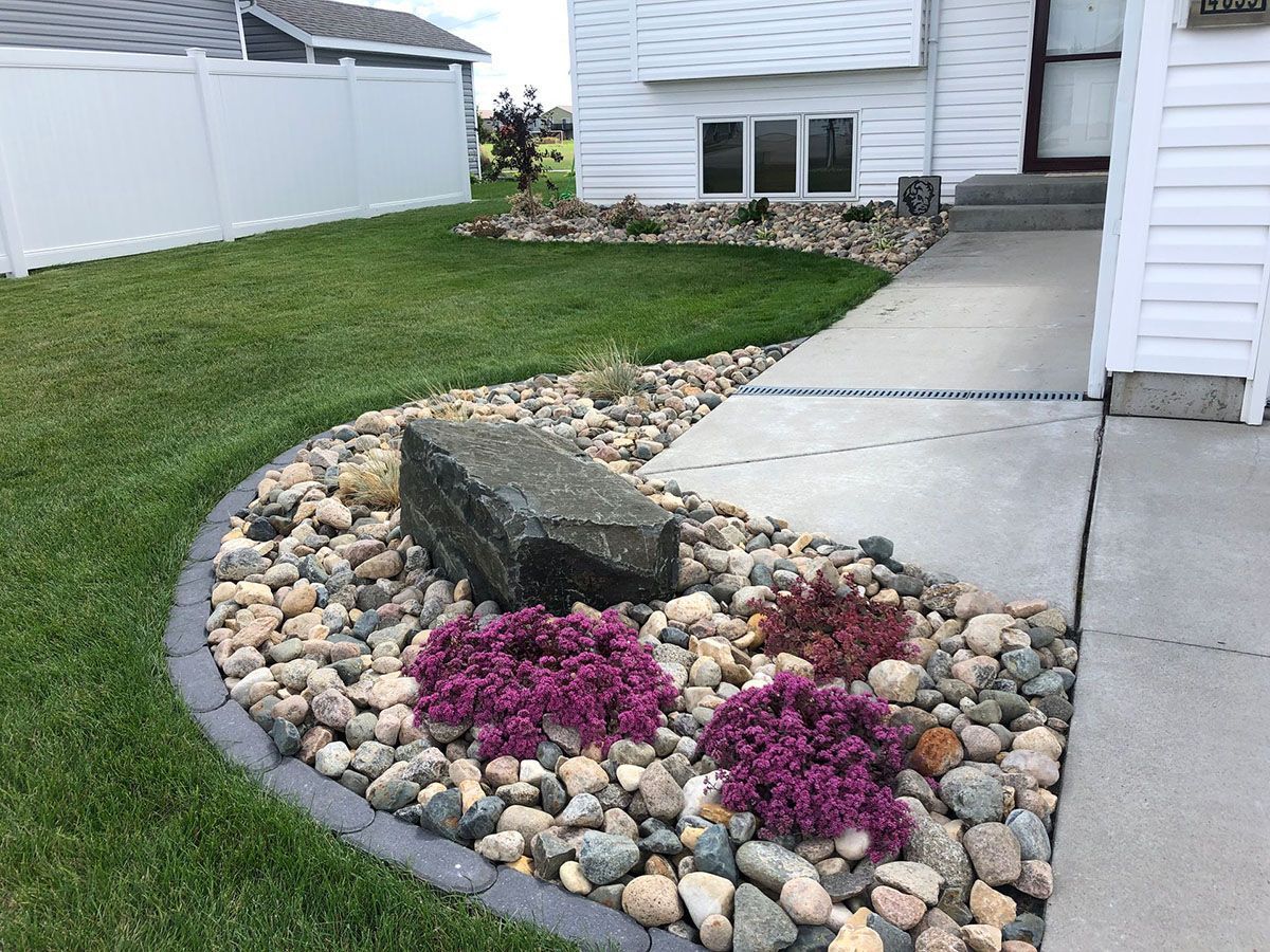 A front yard landscape with a rock bed