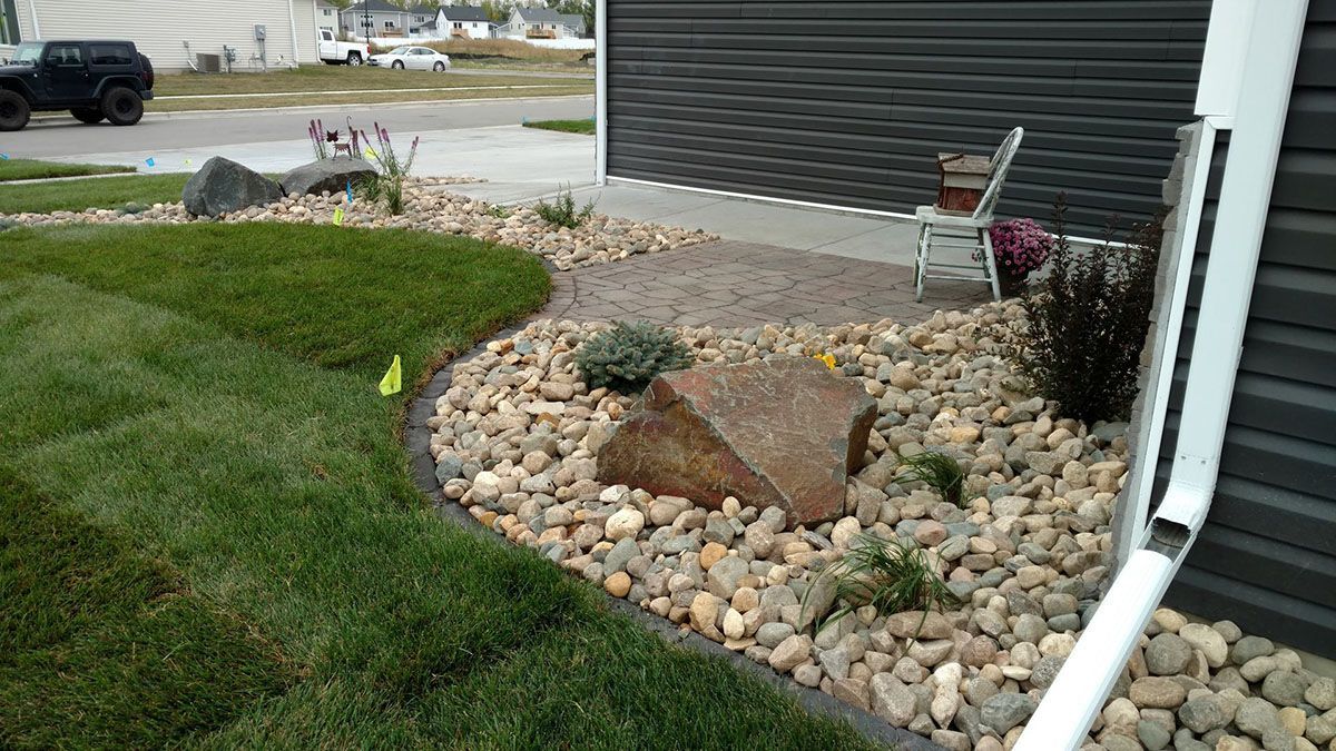 A landscaped yard with decorative river rocks