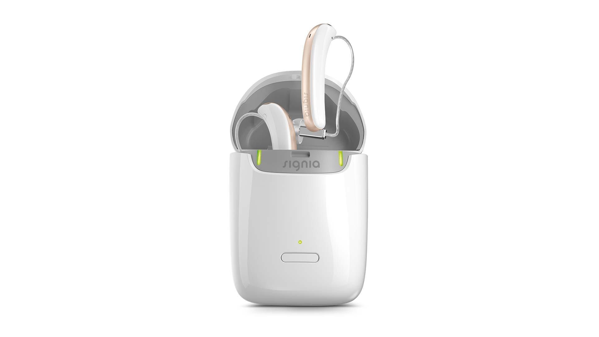 A pair of hearing aids in a charger on a white background.