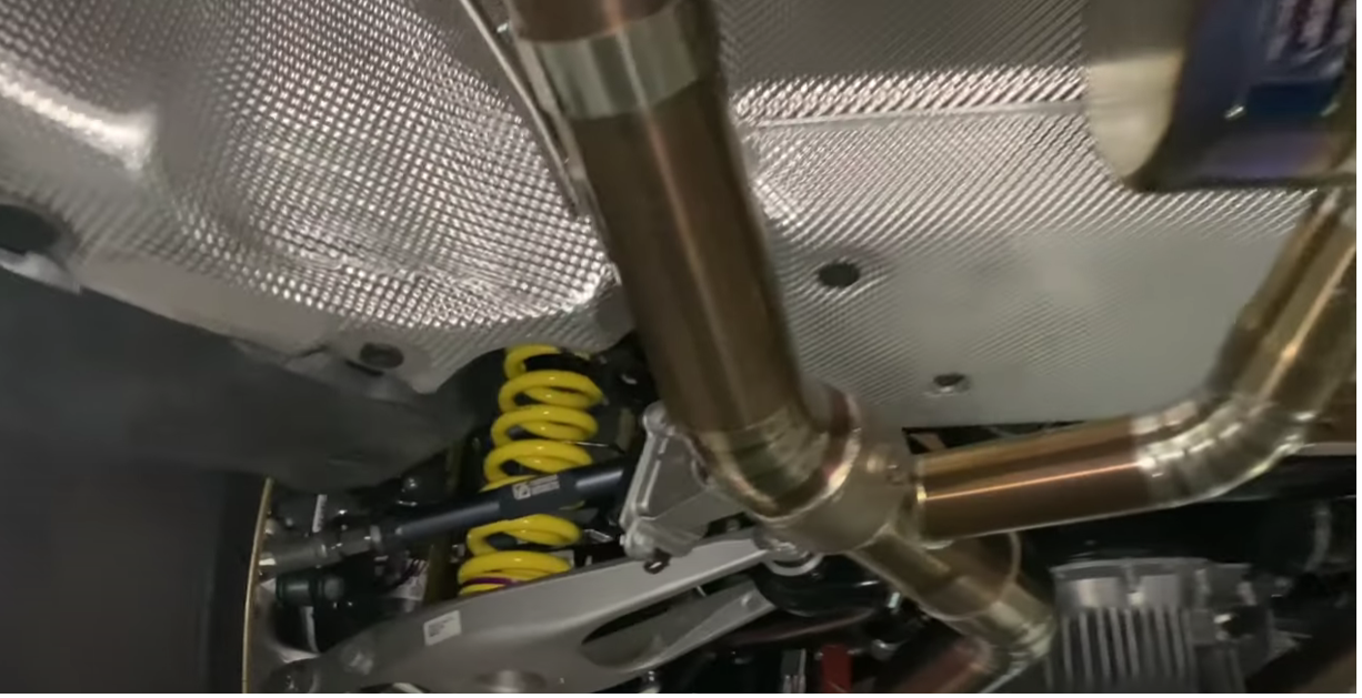 A close up of the underside of a car with a exhaust pipe