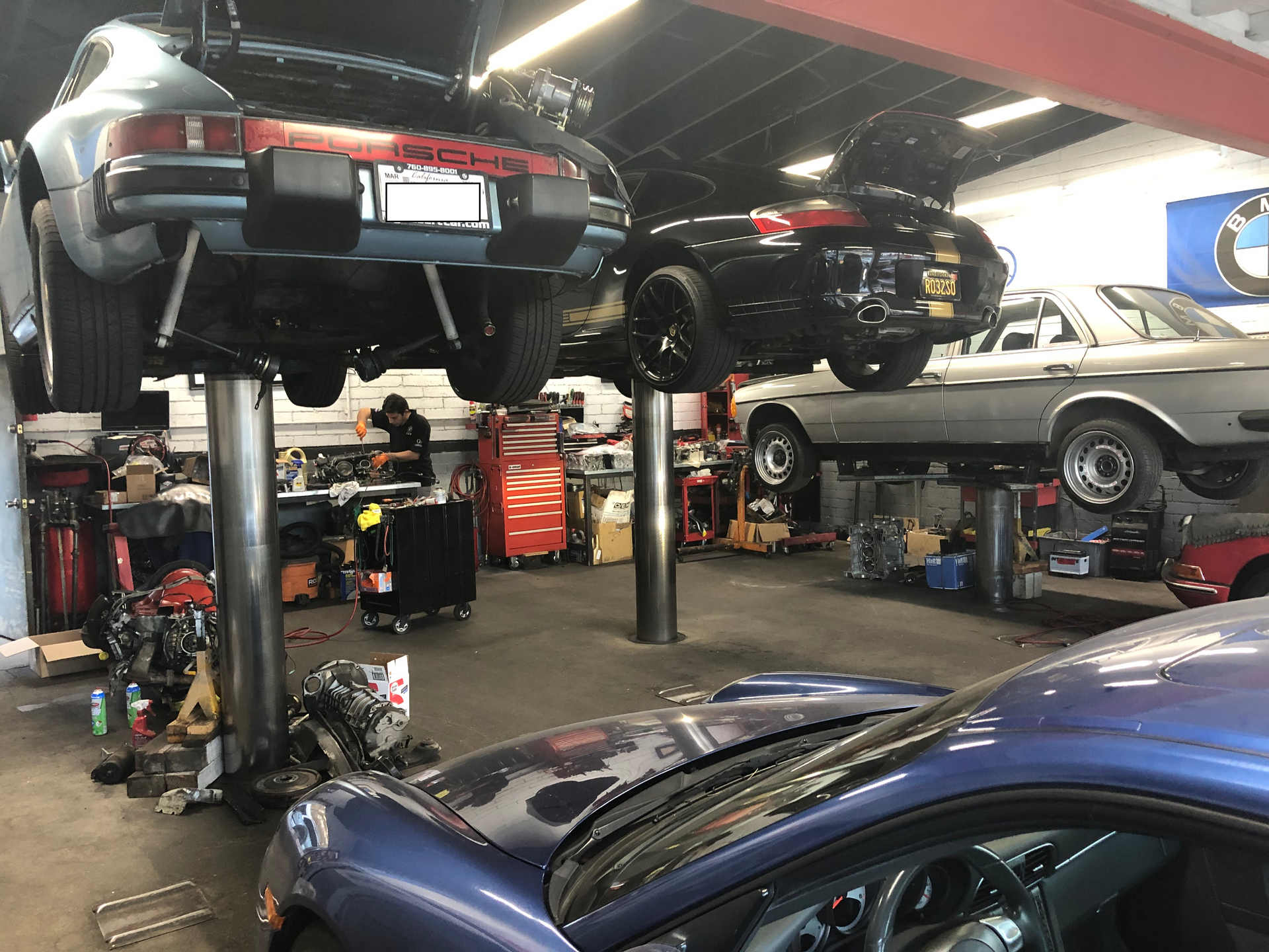 A blue car is sitting on a lift in a garage.