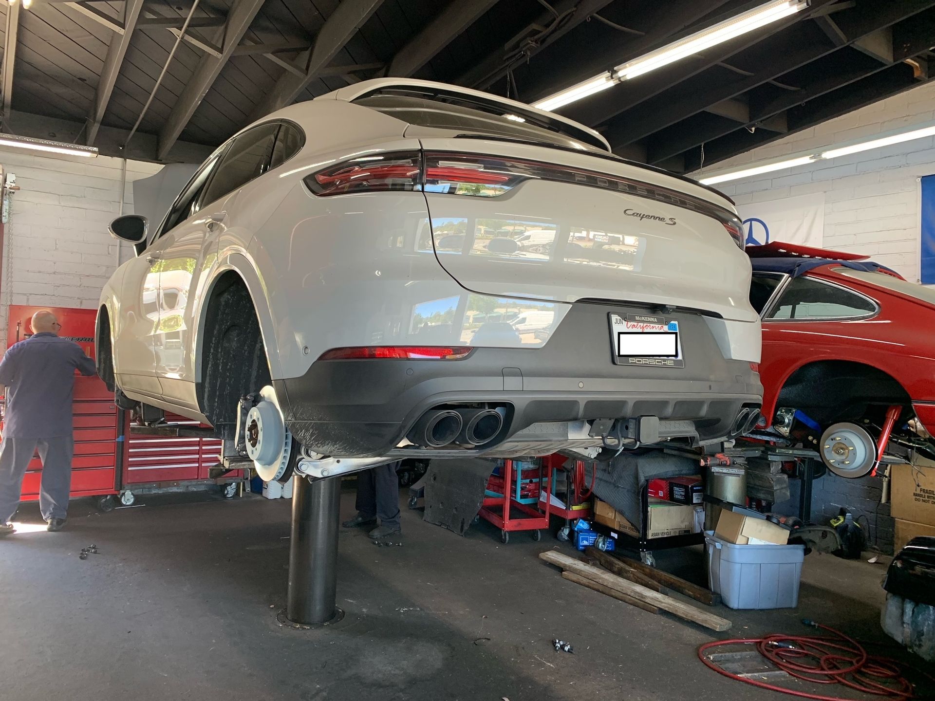 A car is sitting on a lift in a garage.