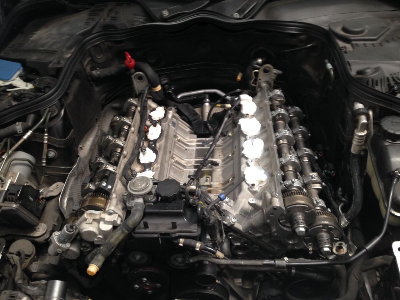 A close-up of a car engine with the hood open.