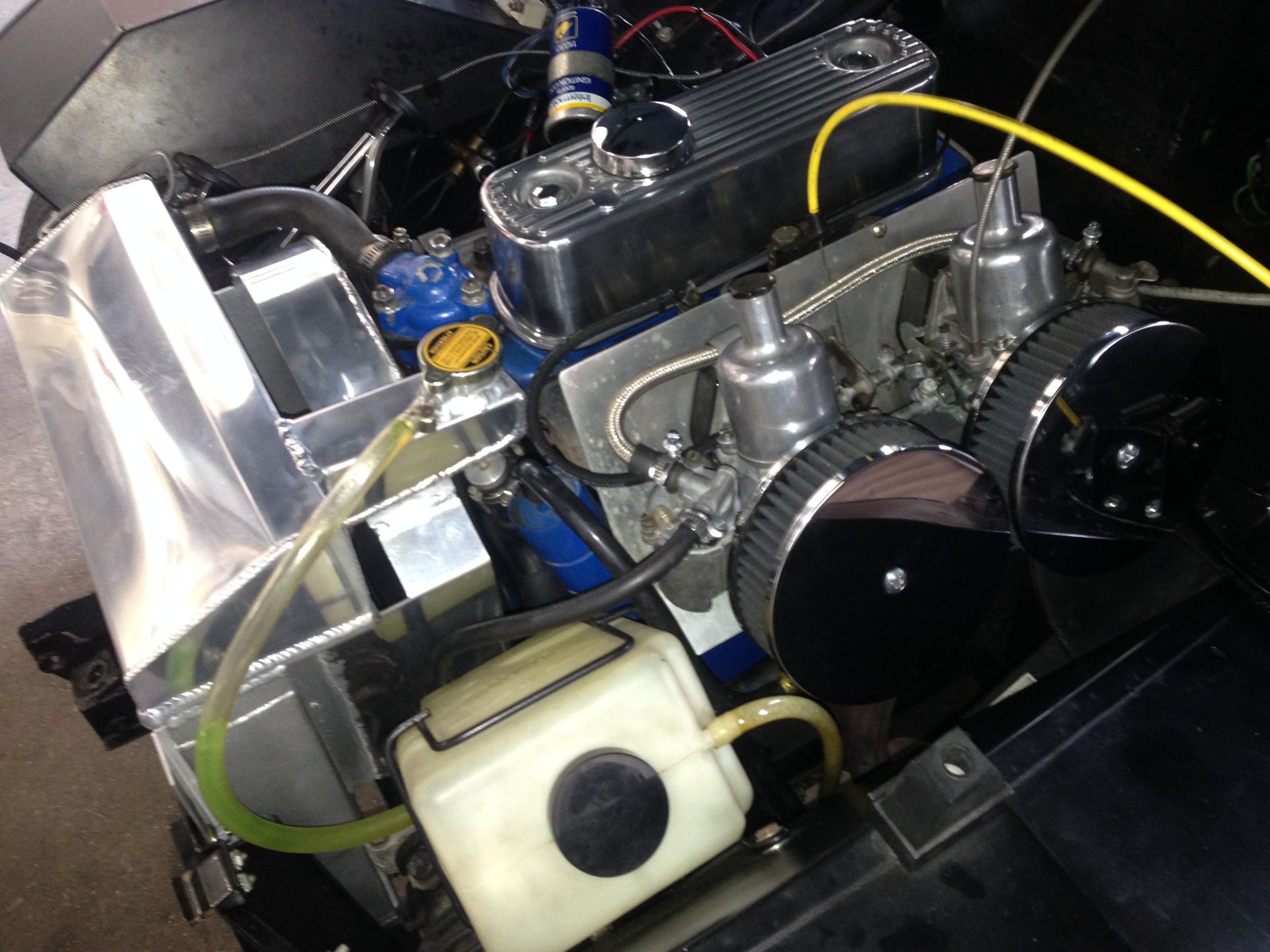 A close up of a car engine with a hose coming out of it.