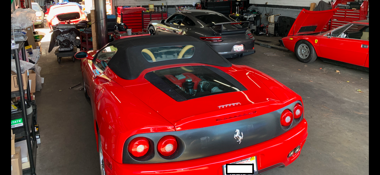 A red Ferrari sports car is parked in a garage.