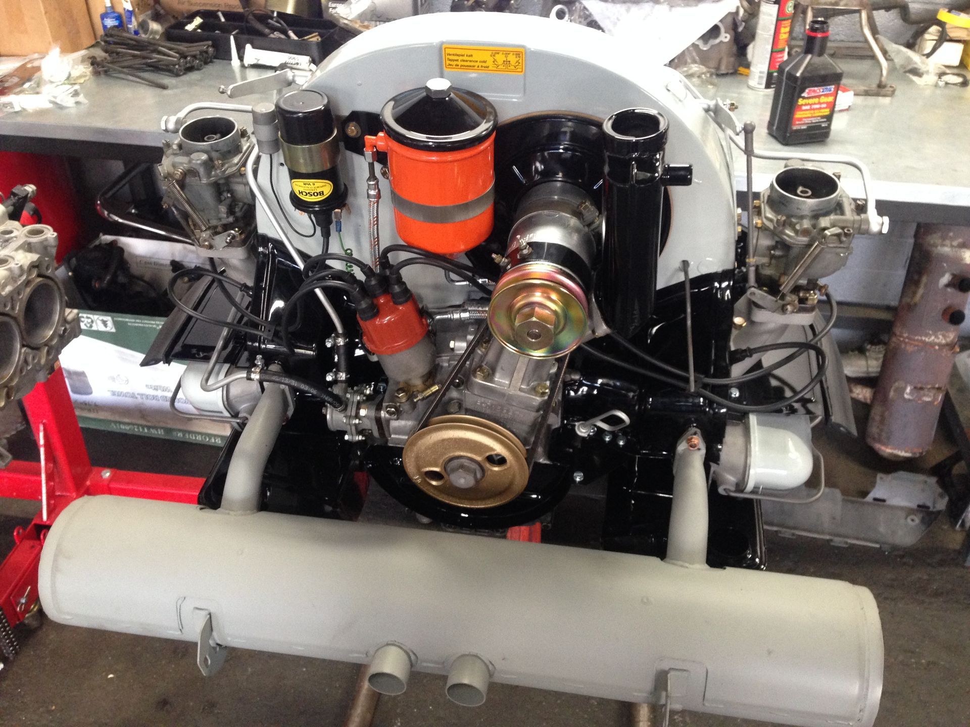 A black and white engine is sitting on a table in a garage.