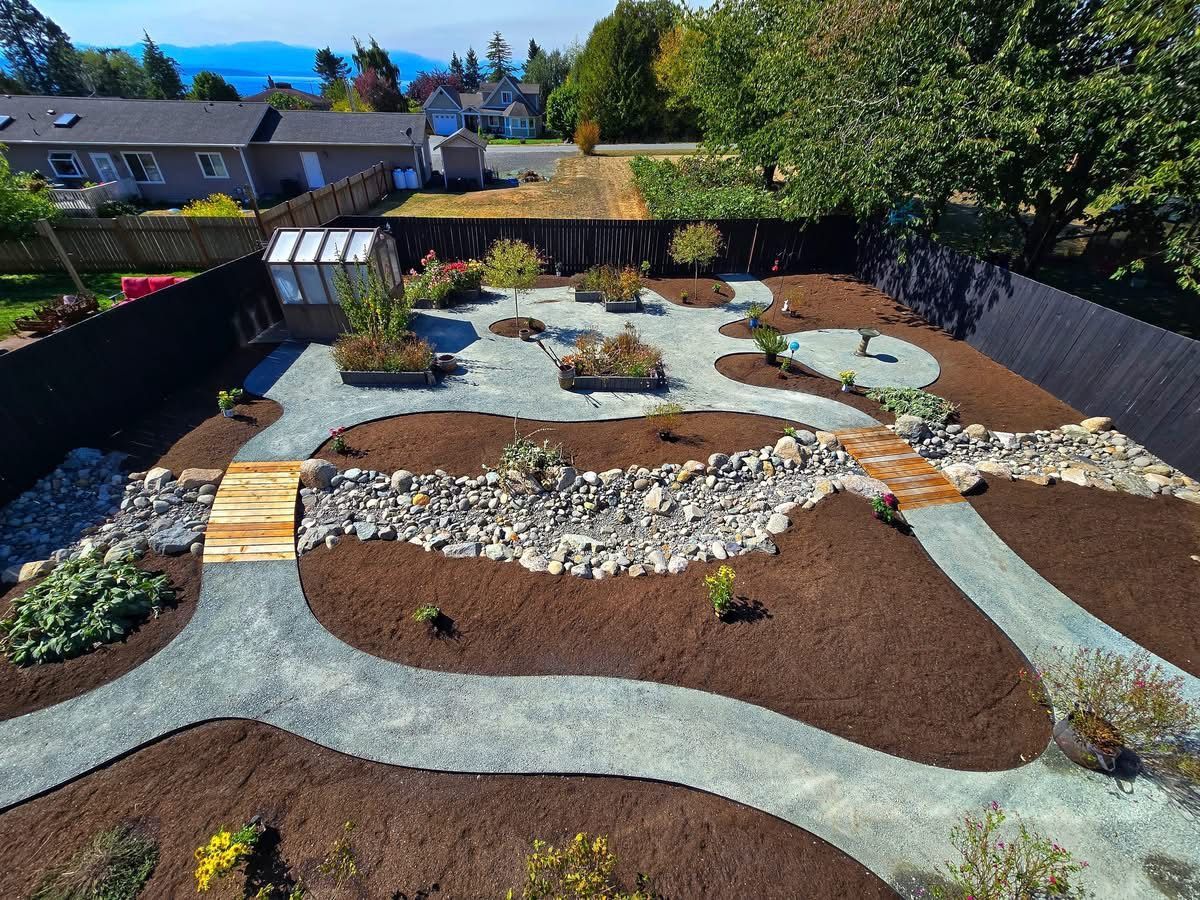 An aerial view of a landscaped garden with gravel paths, wood bridges, and various plants.