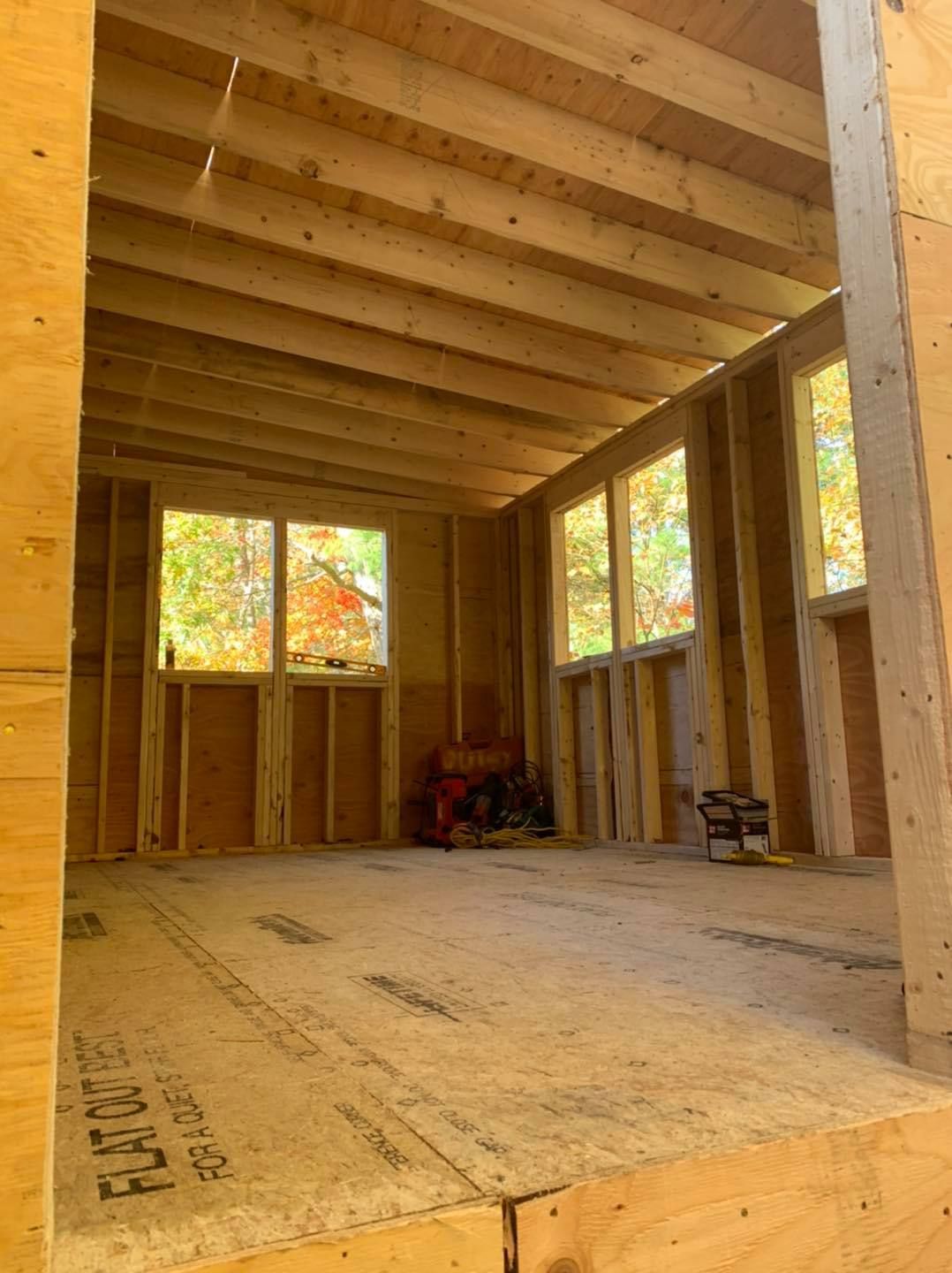 A room with a lot of windows and a wooden floor