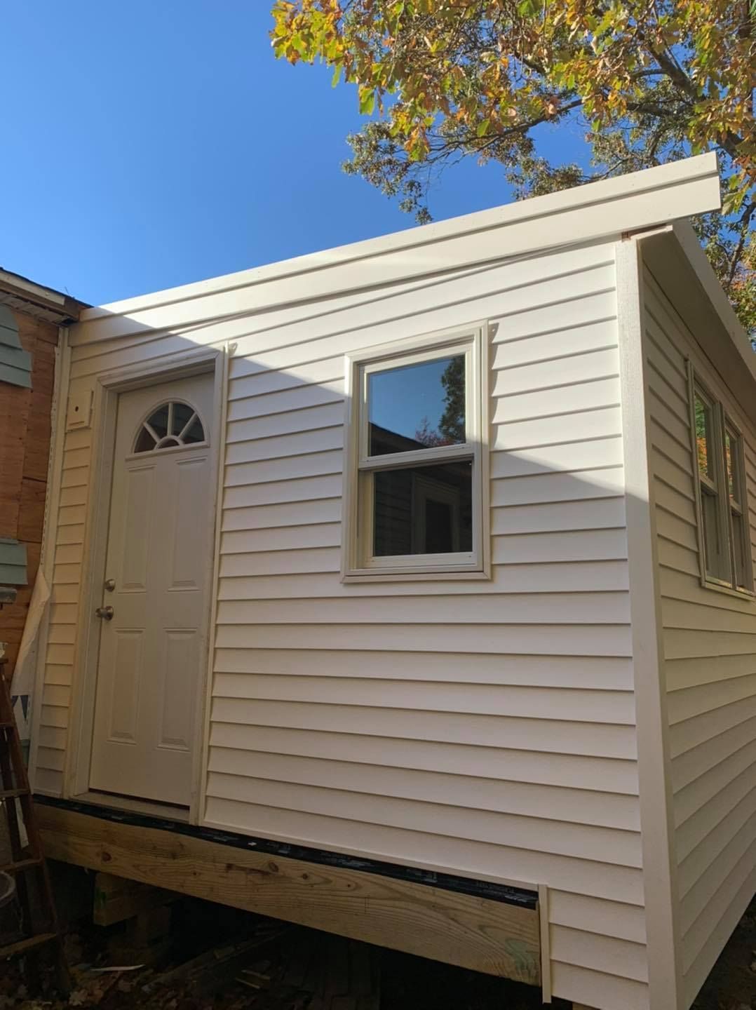 A small white house with a window and a door