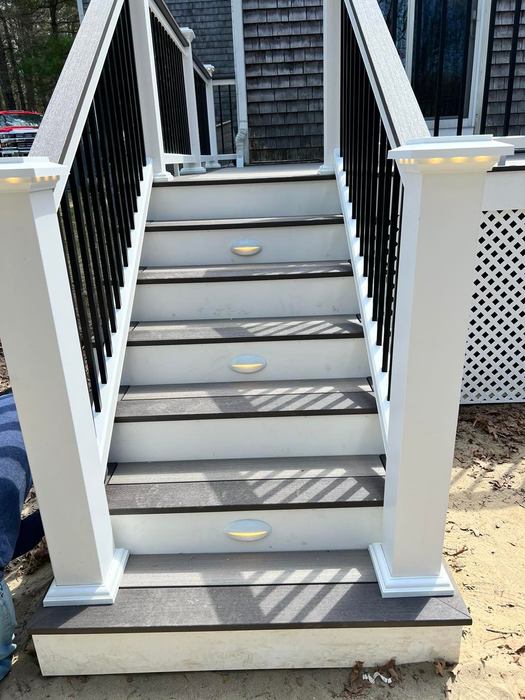A set of stairs leading up to a deck with a white railing