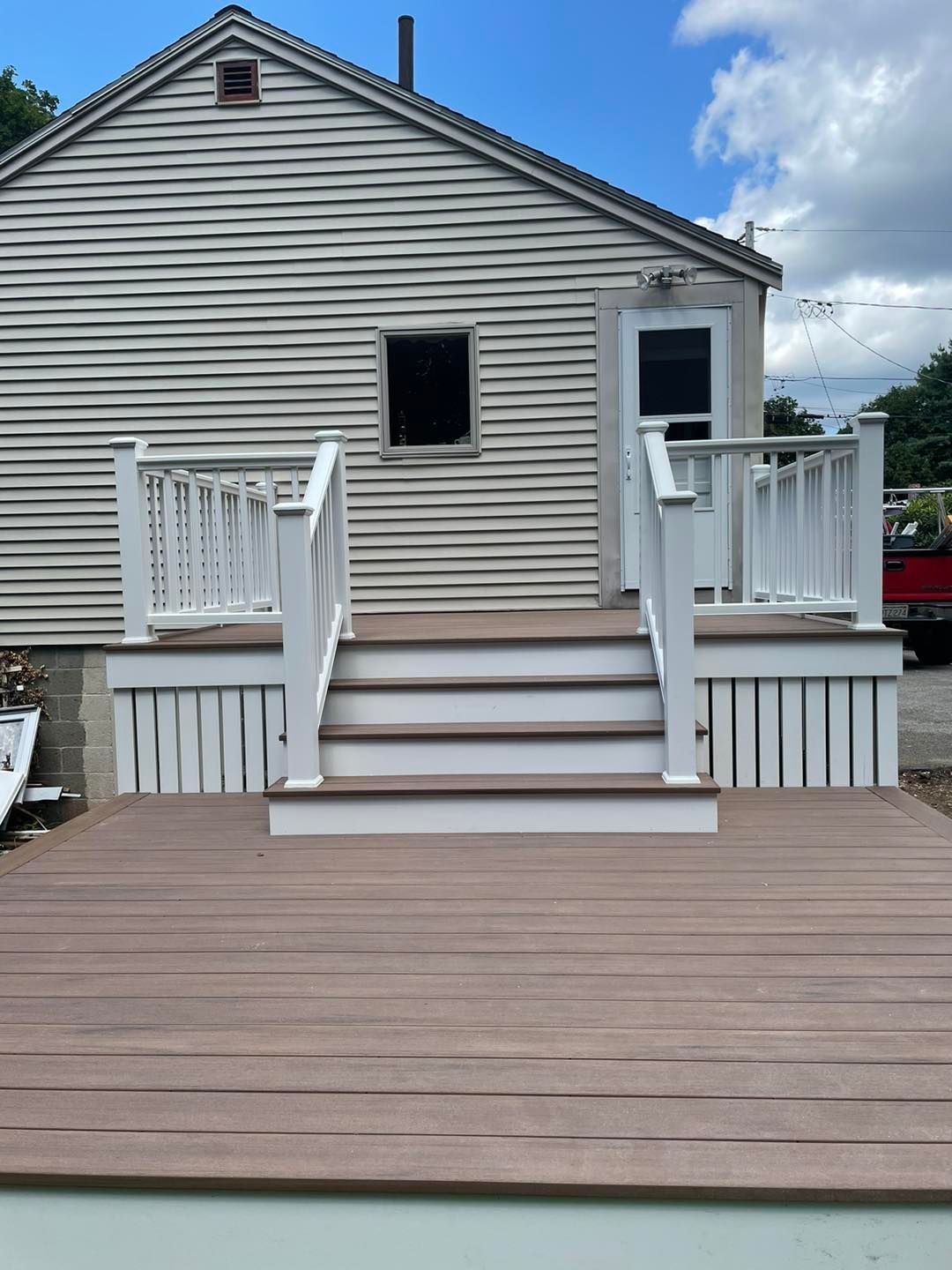A house with a deck and stairs in front of it