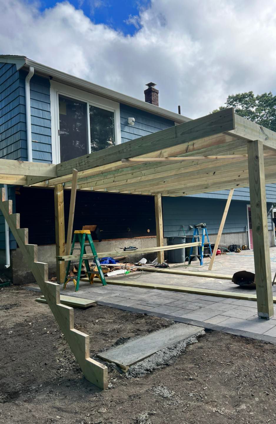A wooden deck is being built in front of a house