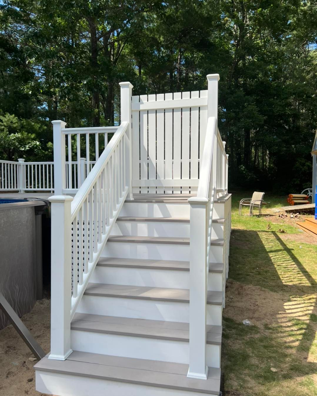 A white deck with stairs leading up to it