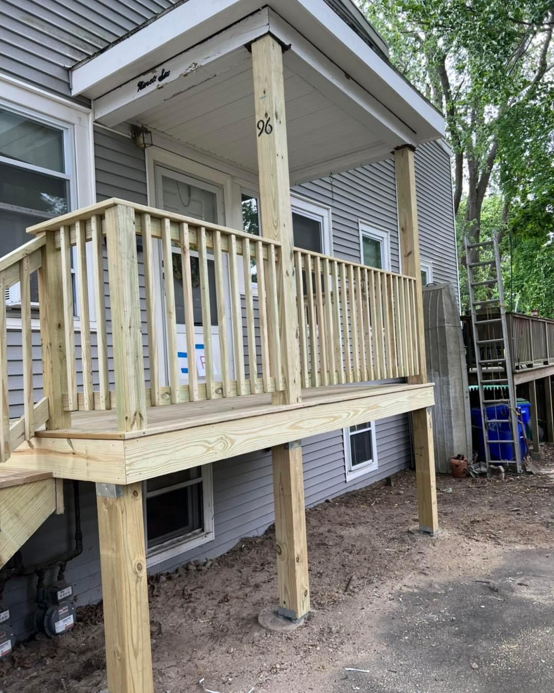 A wooden deck is being built on the side of a house