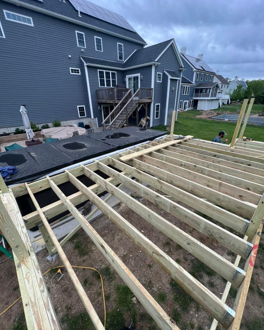 A wooden deck is being built in front of a house