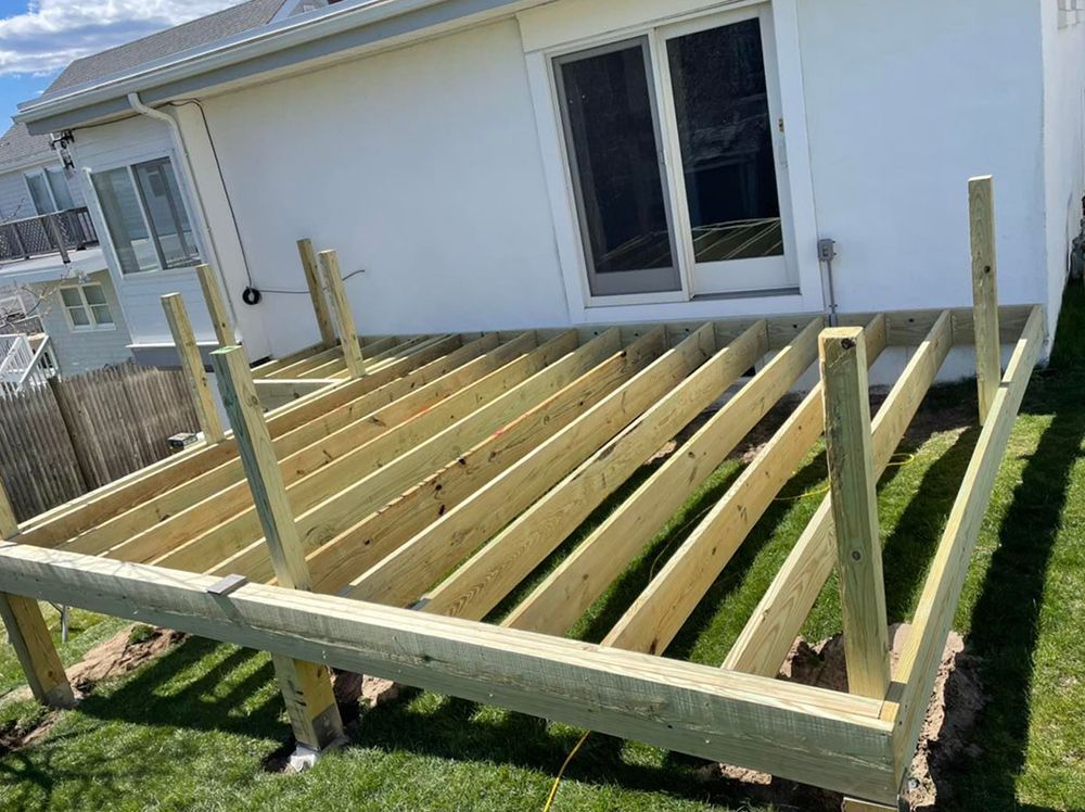 A wooden deck is being built in front of a house