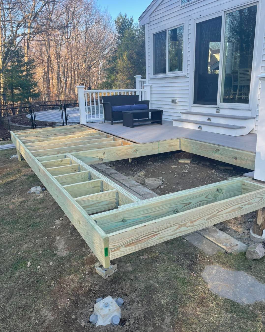 A wooden deck is being built in front of a house