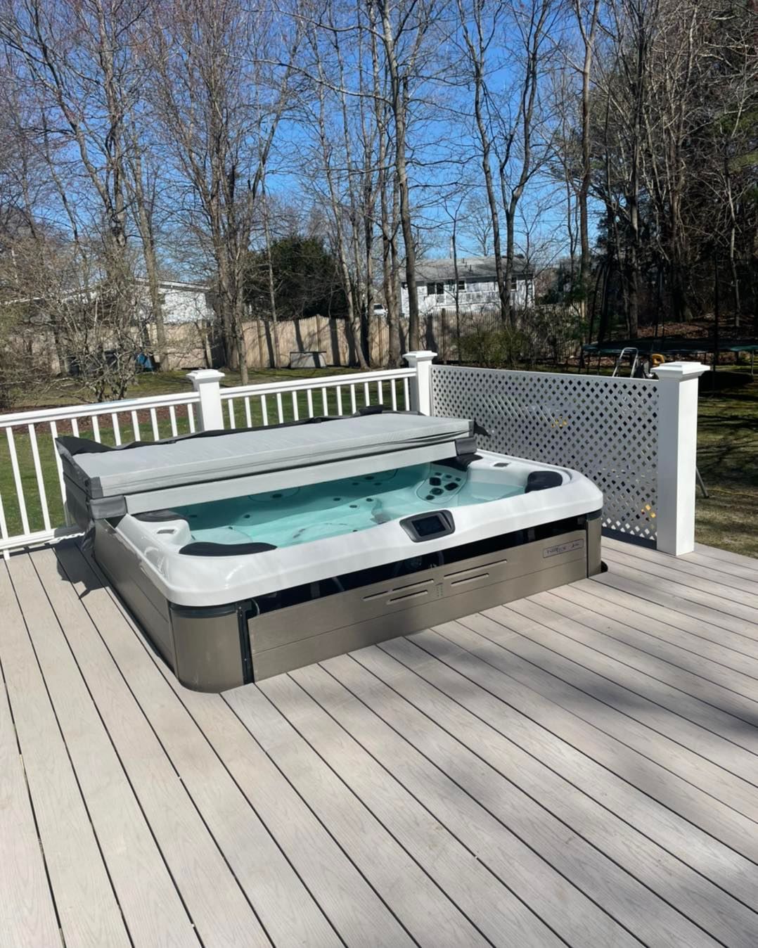 A hot tub is sitting on top of a wooden deck