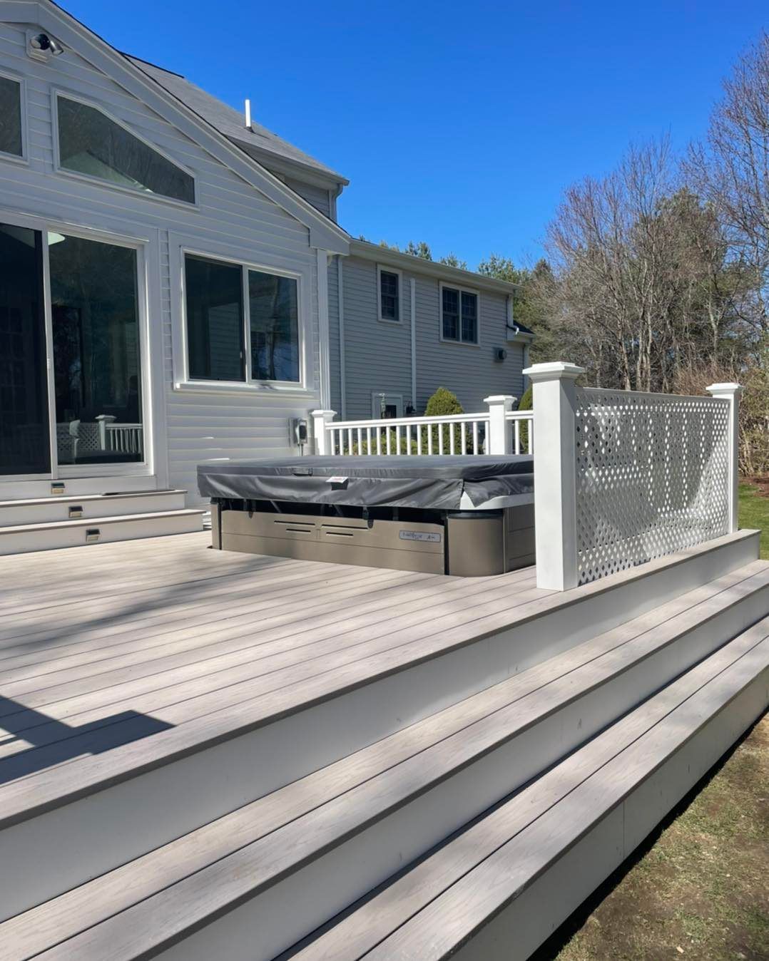 There is a hot tub on the deck of a house