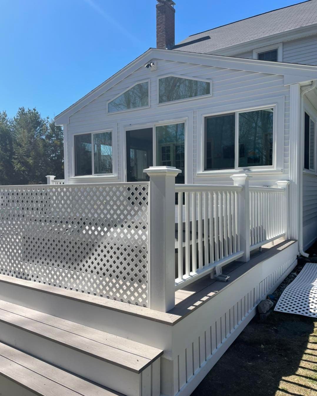 A white house with a white fence and stairs