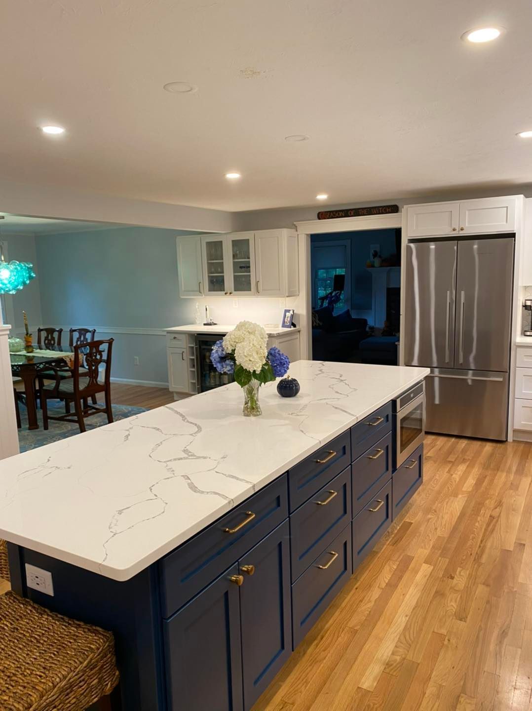 A kitchen with a large island and a vase of flowers on the counter