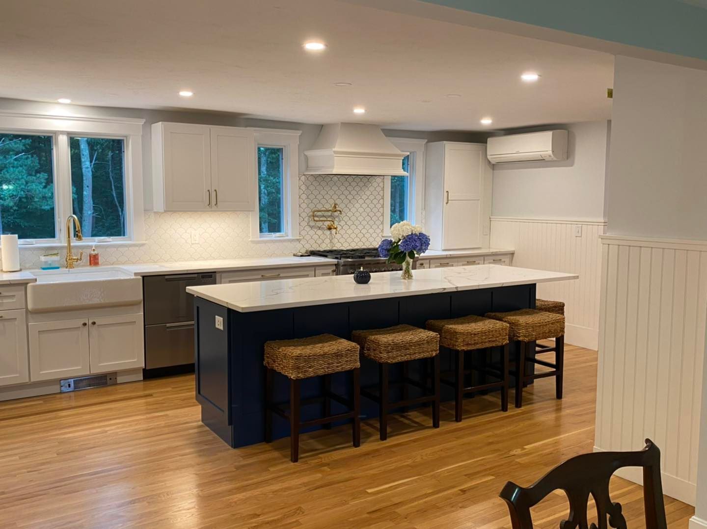 A kitchen with a large island and stools in it