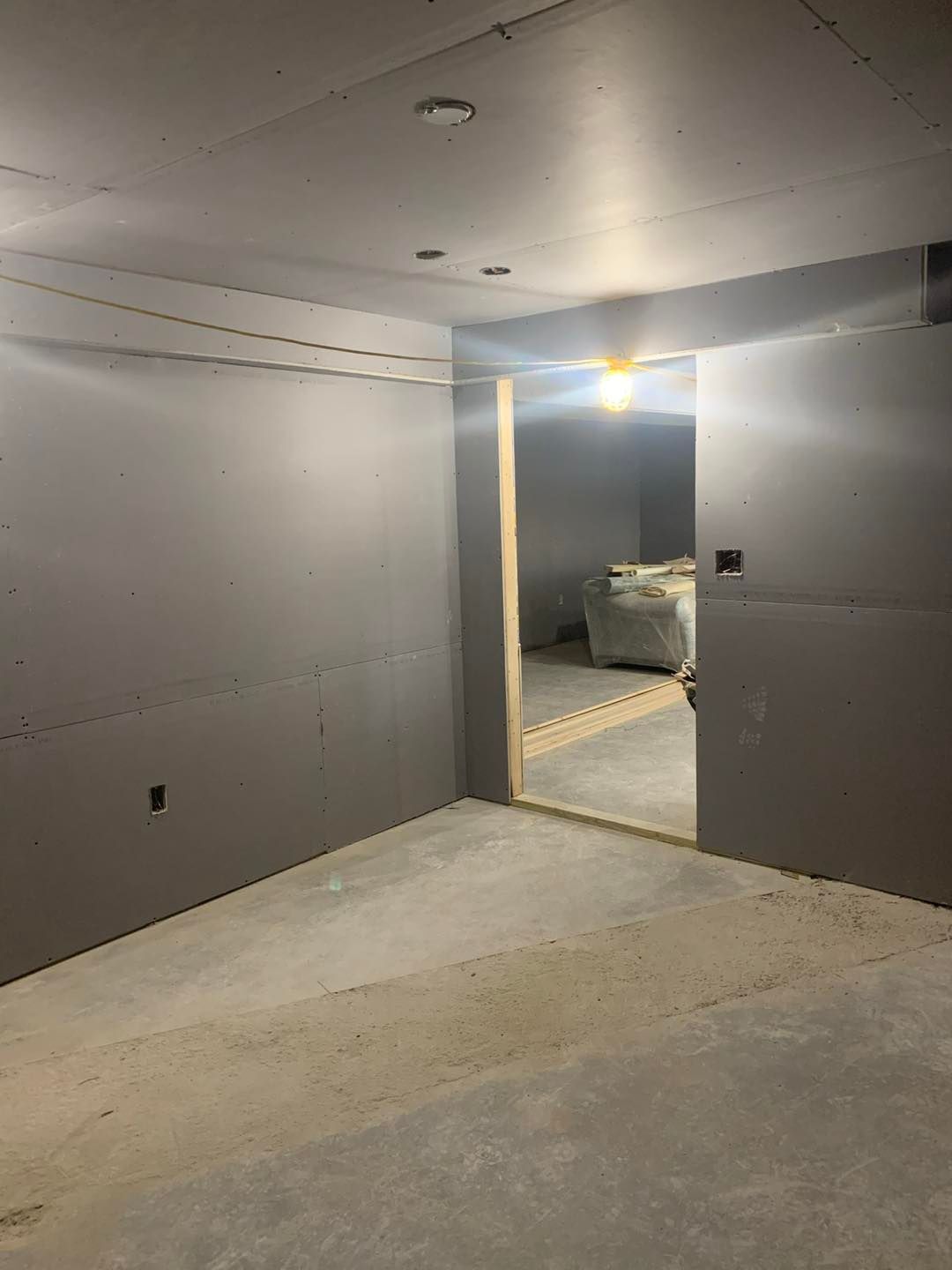 An empty room with a doorway leading to a living room