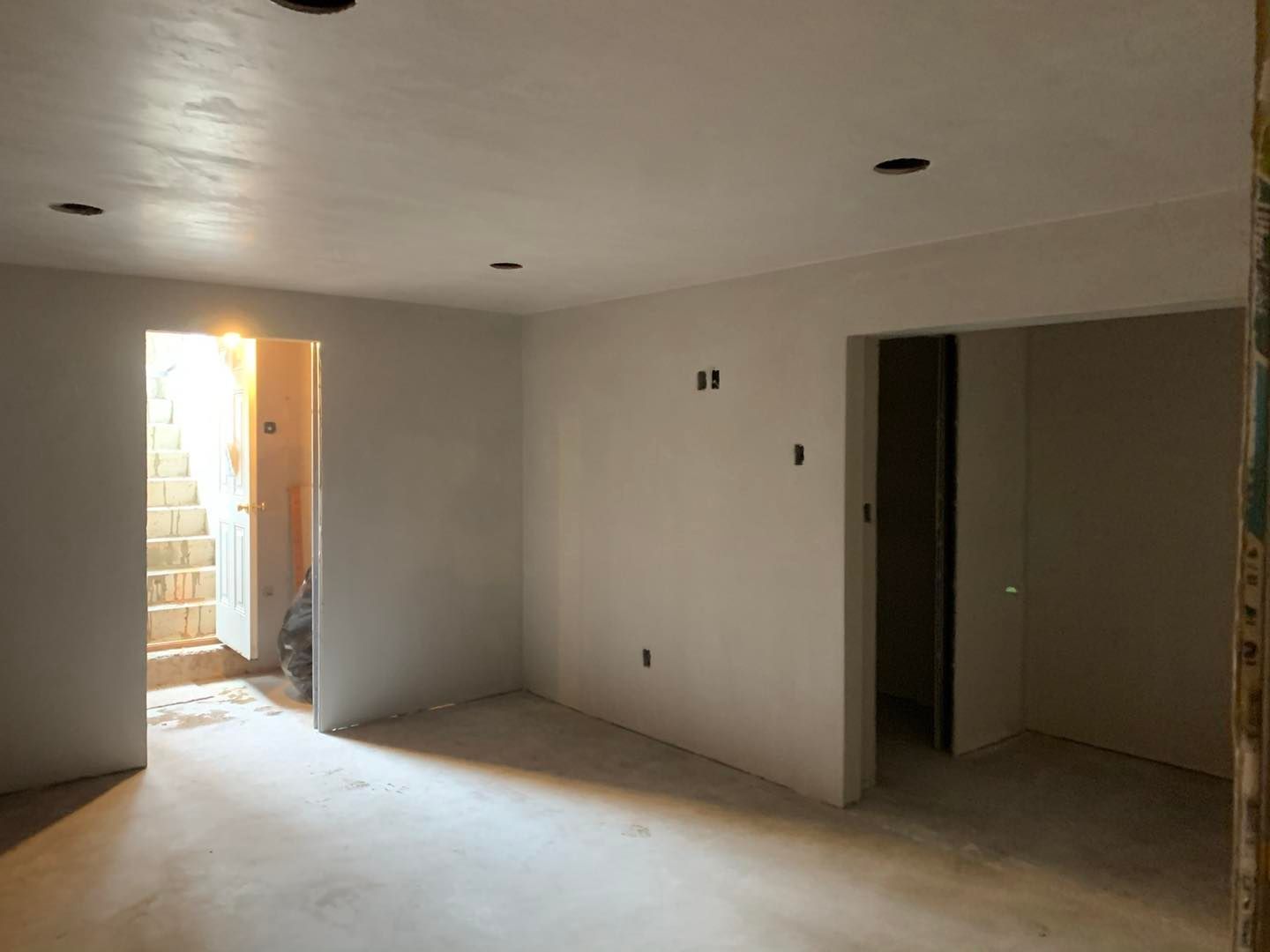 An empty room with white walls and a doorway