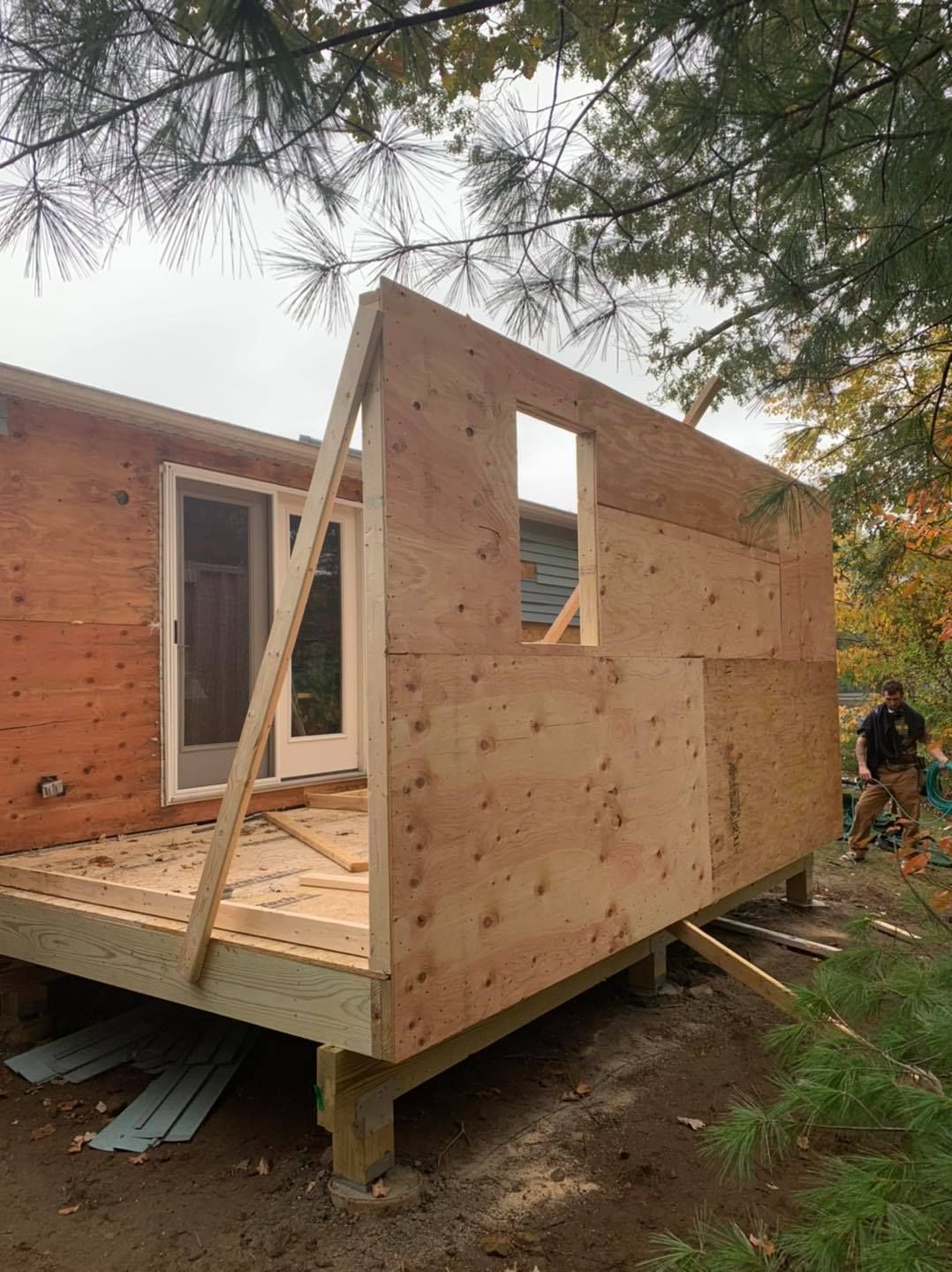 A wooden house is being built with a deck attached to it