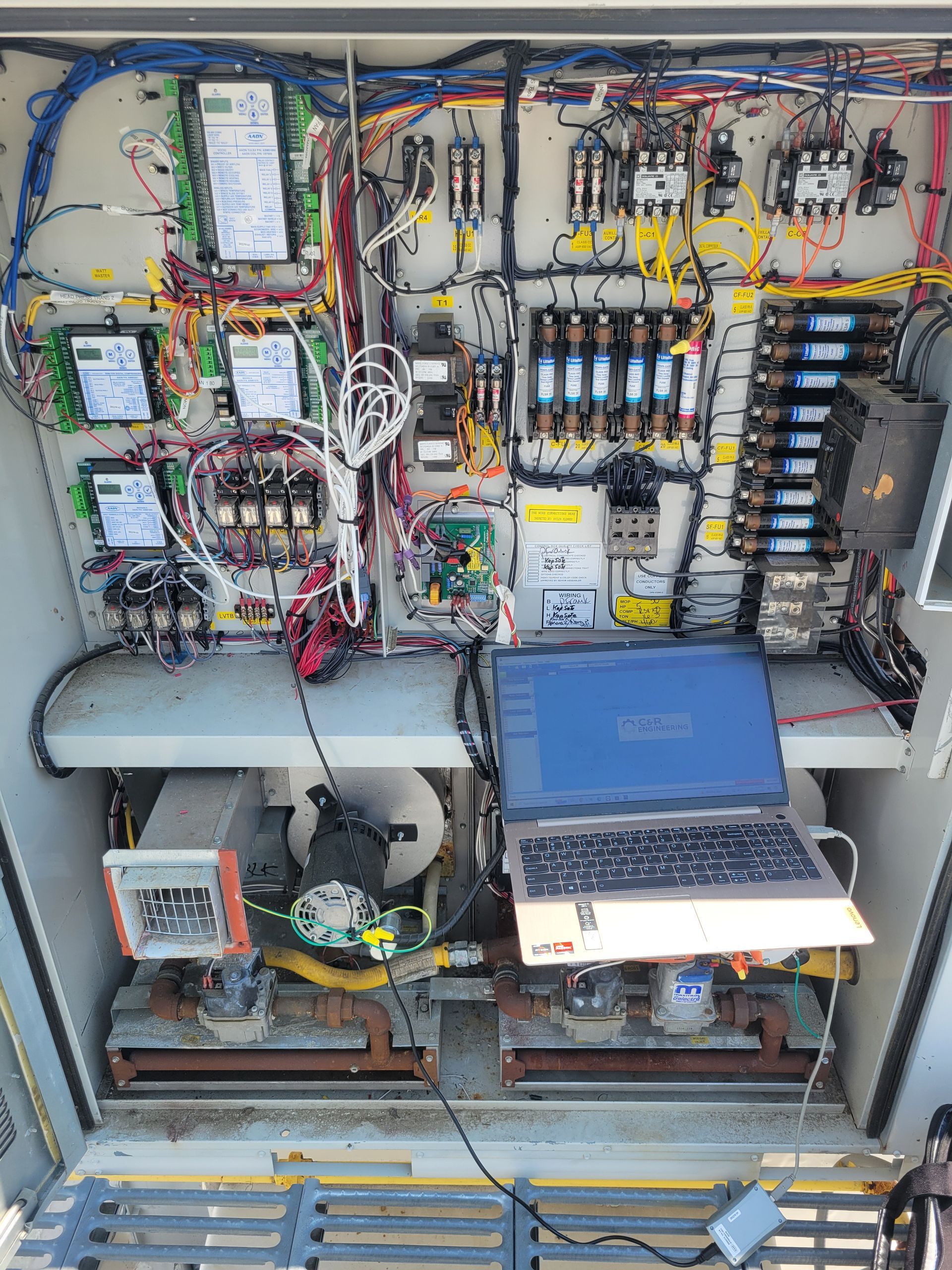 A laptop is sitting on top of a large electrical box.