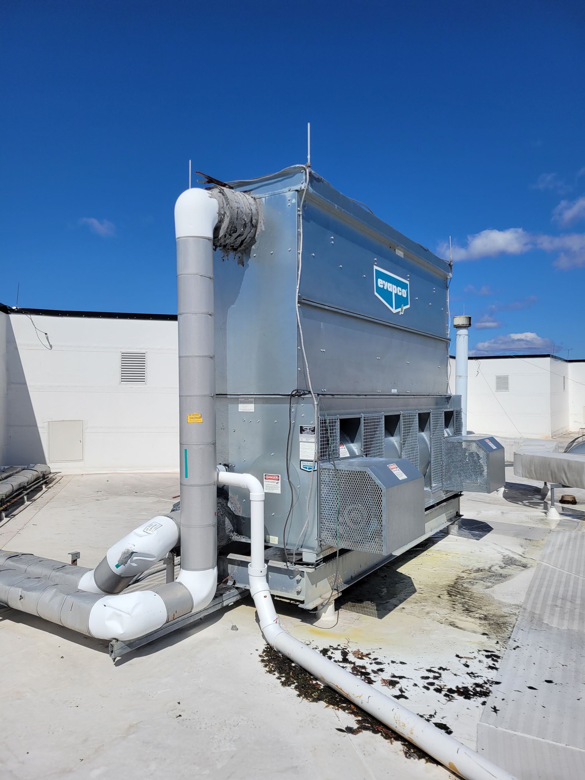 A large machine is sitting on the roof of a building.