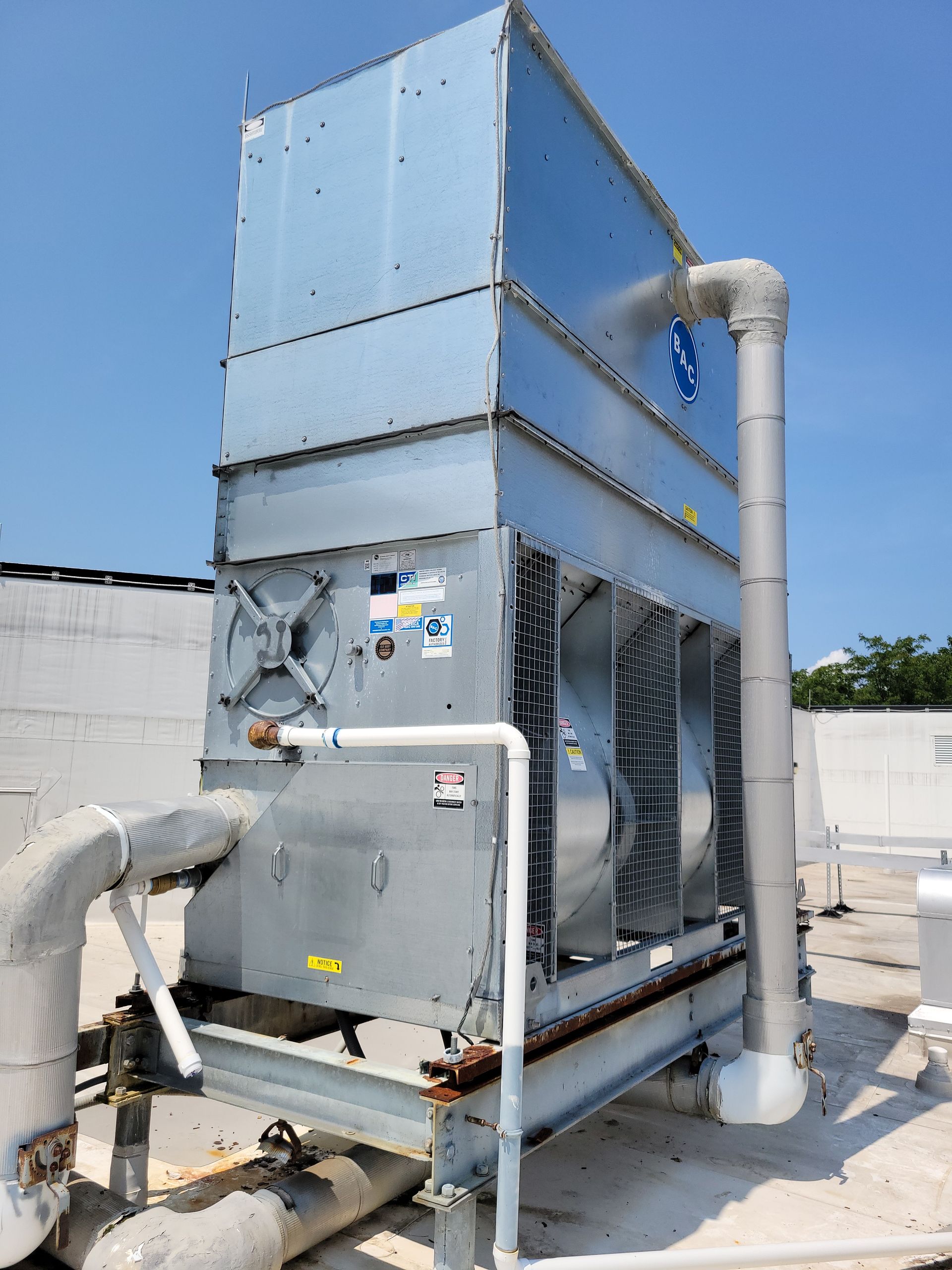 A large cooling system is sitting on top of a building.