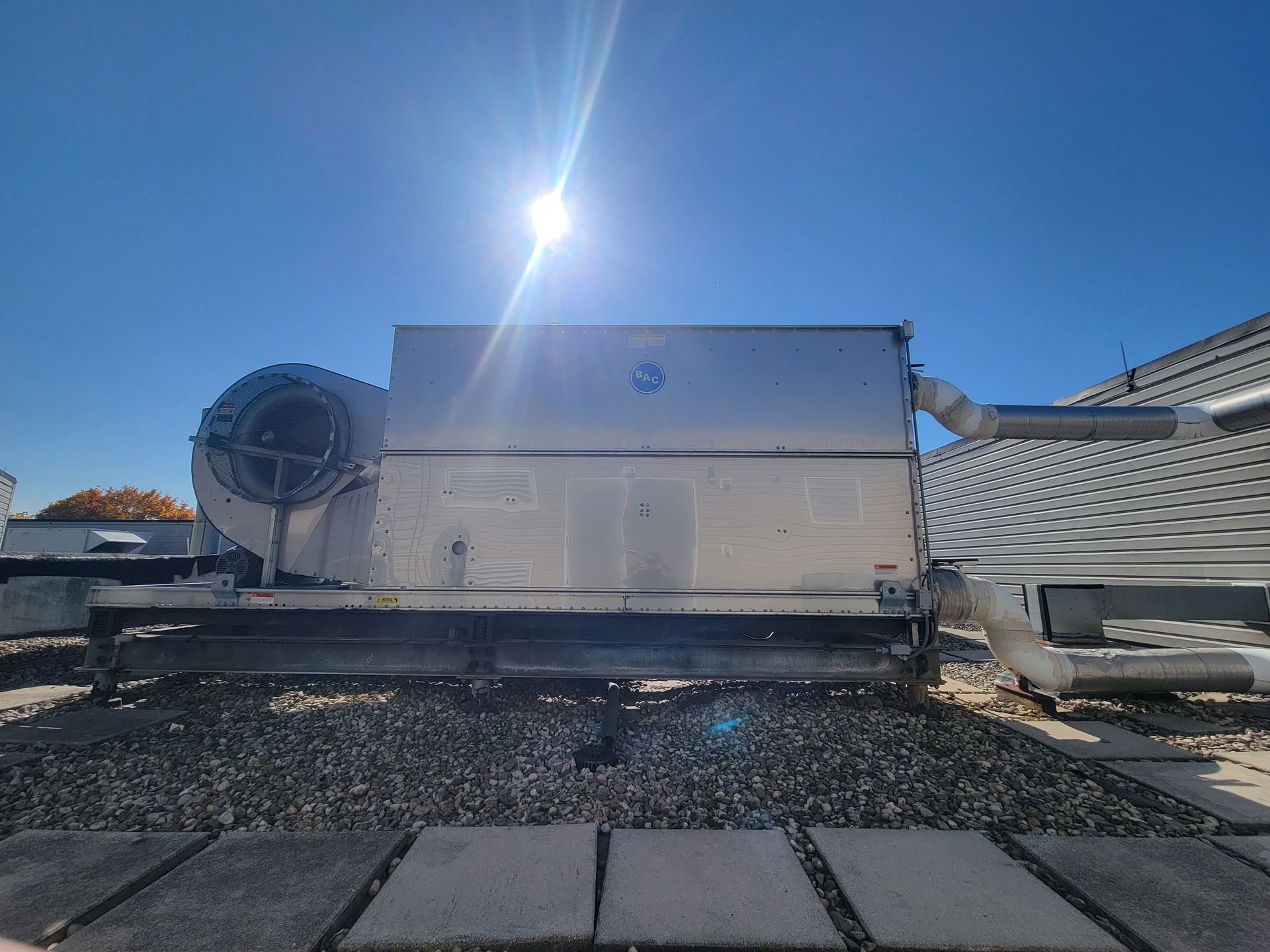 A large metal box is sitting on top of a gravel road.